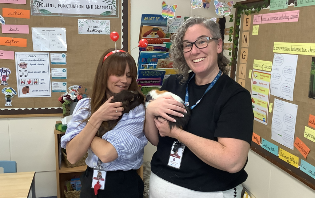 Teachers petting guinea pig