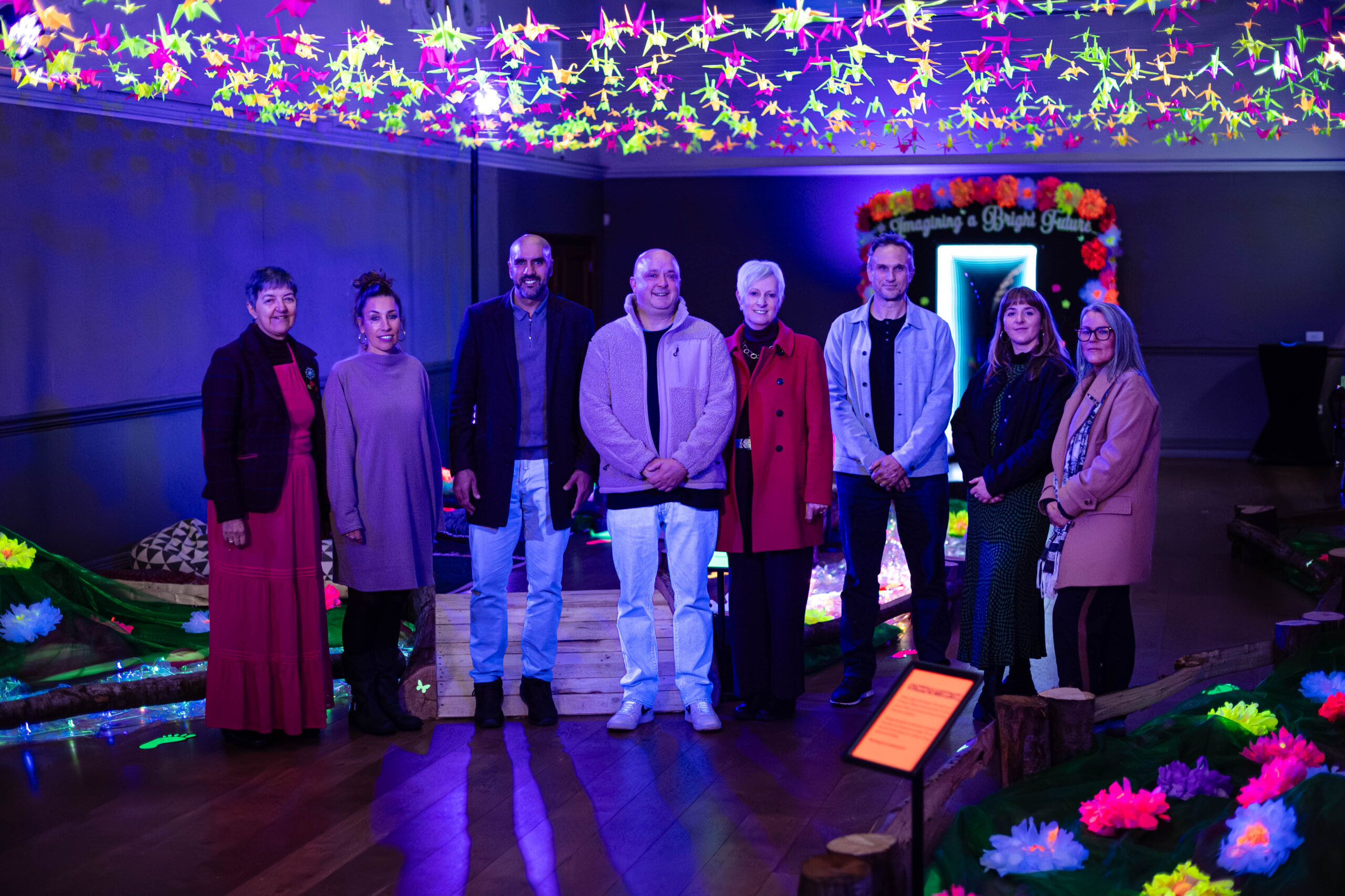 A group of people stand in a room full of lights