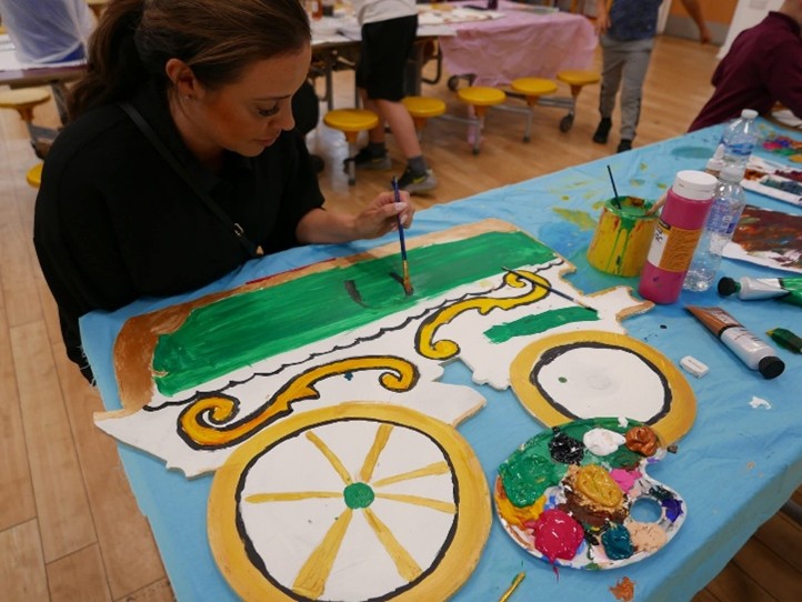 a woman painting a vardo caravan cut out